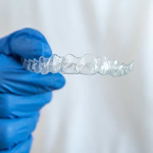 Guantes que sujetan un retenedor dental